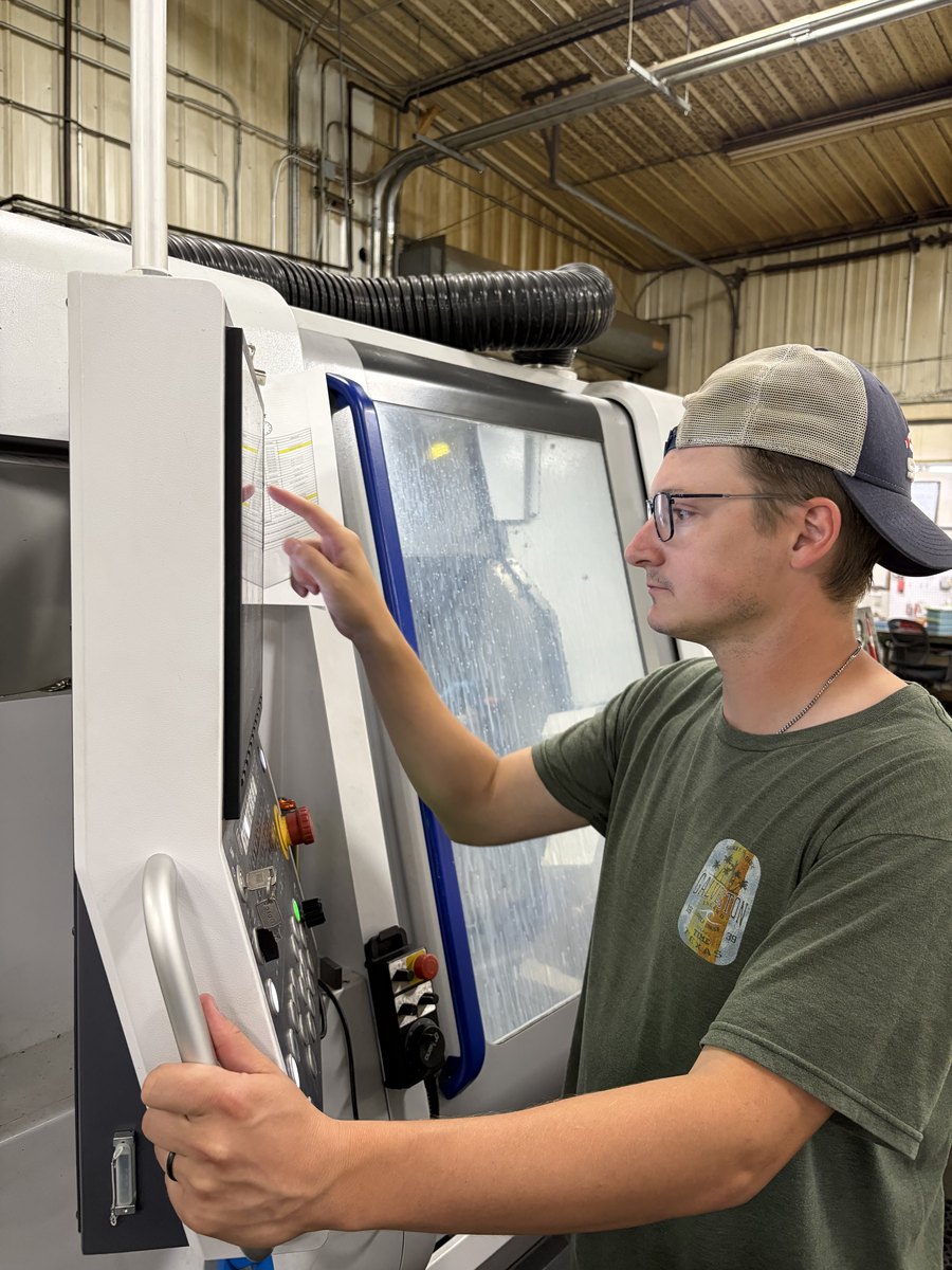 A Marble Arms machinist at a CNC control panel